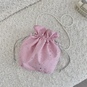 Detailed macro view of pink canvas drawstring bucket bag with silver star pattern