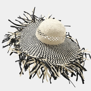 Detailed herringbone weave pattern and raw frayed edges on a raffia sun hat