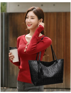 Close-up of black tote bag with skull embossing and stylish double tassel charms