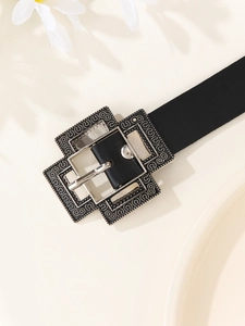 Detailed shot of vintage silver buckle with floral engraving on a black PU leather belt