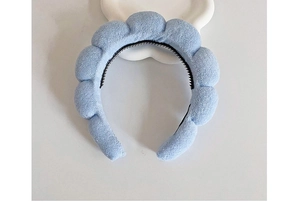 Detail of light blue bubble headband with non-slip teeth on white floral background