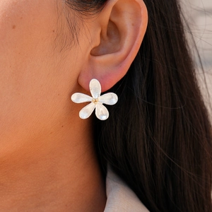 Detail of two-tone petal stud earrings with brushed texture on model's ear