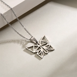 Detail view of a silver origami butterfly pendant with a hollow geometric design on a chain