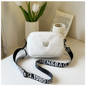 Detail of white nylon crossbody bag with silver butterfly and lettered wide strap