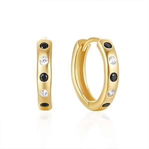 Close-up of gold hoop earrings featuring alternating black and white cubic zirconia stones