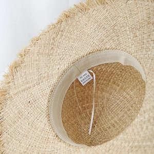 Détail de l'intérieur d'un chapeau de soleil en raphia avec bandeau et étiquette 100% papier