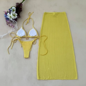 Flat lay of yellow three-piece bikini set with mesh skirt and starfish metal buckle