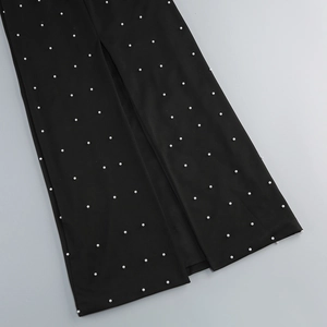 Gros plan détaillé de la robe bustier noire ornée de perles avec une fente latérale