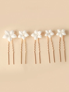 Detail of five white ceramic flower hair pins with crystals and golden U-shaped needles