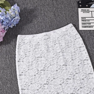 Close-up of white lace skirt with intricate hollow crochet detailing on a textured base