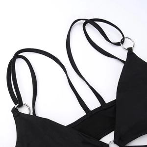 Detail of black lace bodysuit featuring thin straps and polished metal ring hardware