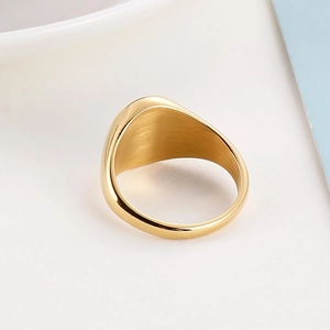 Detail of gold signet ring featuring brushed inner and polished outer metal finishes