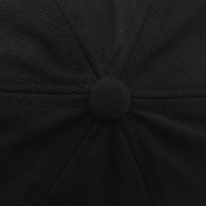 Détail de la calotte d'une casquette en coton sergé noir avec bouton et coutures