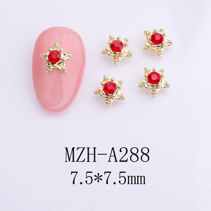 Macro shot of 7.5mm star nail charms with gold alloy base and red rhinestones