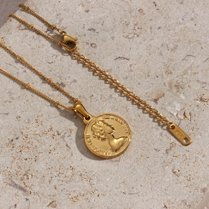 Classic golden coin necklace featuring an Elizabeth II portrait pendant on white stone