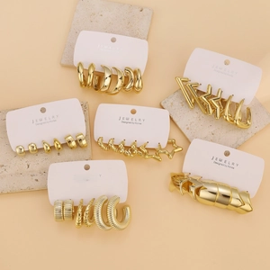 Detail of diverse gold-tone C-shape earrings set on jewelry display card