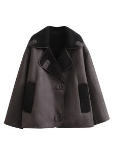 Détail d'une veste en daim marron foncé avec doublure en peau lainée noire et large col