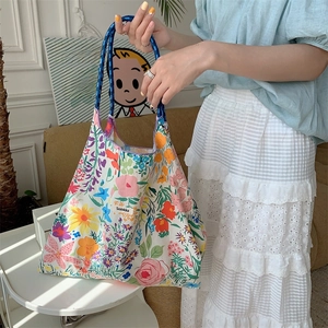 Detail of floral canvas tote bag with woven rope handles and vibrant flower patterns