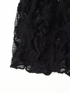 Gros plan détaillé des motifs floraux en dentelle noire et du tissu ajouré délicat