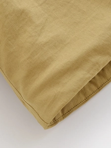 Close-up of khaki cotton fabric with detailed stitching and twill weave texture