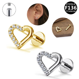 Macro detail of sterile G23 titanium heart-shaped ear studs in gold and silver finish