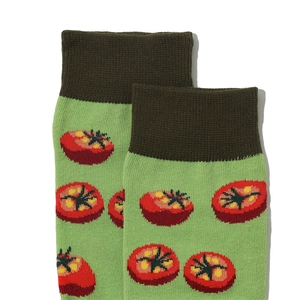 Detail of green cotton crew socks with vibrant red tomato patterns and ribbed cuffs