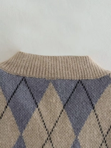 Detail of rib-knit crew neck and argyle pattern on vintage style knitted vest