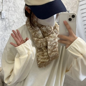 Close-up of soft beige and brown knit scarf showing premium chunky woven texture