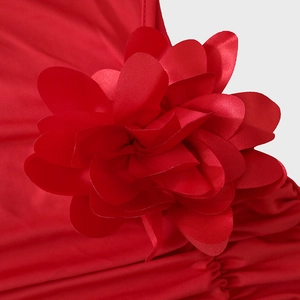 Close-up of a large 3D red fabric flower detail on the elegant satin evening dress