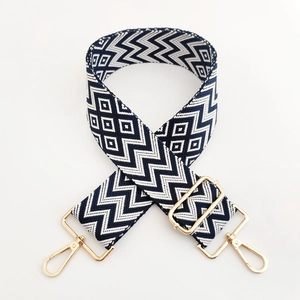 Detail of adjustable blue and white wavy geometric woven strap with gold metal hooks