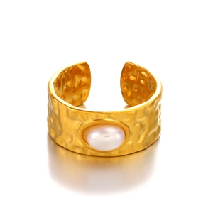 Gold hammered wide band ring with an oval pearl inlay against a white background