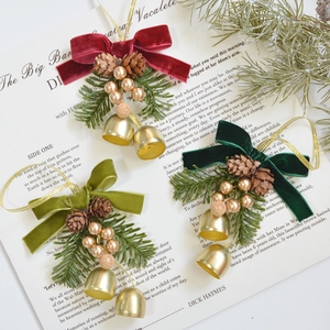 Christmas velvet bow ornaments with pine cones and golden bells on white paper
