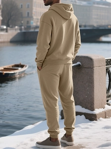 Detail view of khaki tracksuit showing textured diamond pattern fabric in snowy outdoor setting