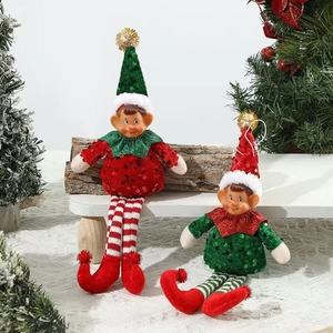 Christmas elf plush dolls with red and green sequins sitting on a festive wood beam decoration
