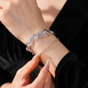 Close-up of vintage multilayer silver bracelets with geometric charms and blue beads
