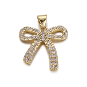 Detailed view of a gold bow pendant encrusted with sparkling clear zircon gemstones