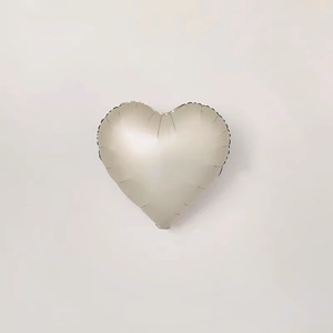 Top view of a heart-shaped silver foil balloon with a metallic finish on a grey background