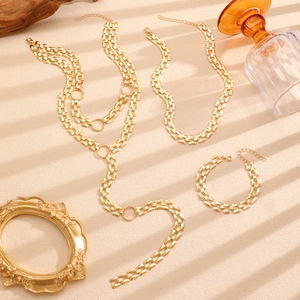 Detail of gold geometric link necklace and body chain with rectangular metal plates