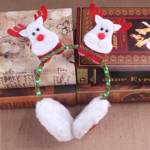 Dettaglio dei paraorecchie natalizi in peluche con corna di renna su libri antichi