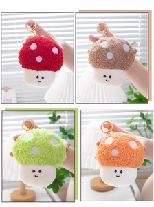 Close-up of four colorful plush mushroom keychains in red, green, orange, and brown tones