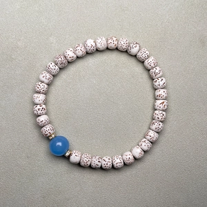 Detailed macro shot of Xingyue Bodhi seeds with a translucent blue agate accent bead