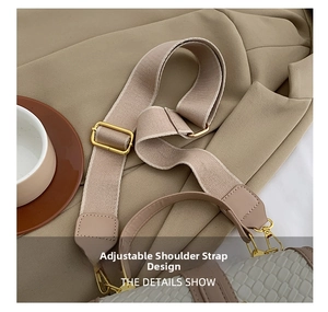 Detail of adjustable wide fabric shoulder strap with gold buckle on beige embossed bag
