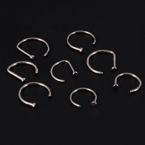 Set of 8 silver G23 titanium C-shaped non-pierced nose and lip rings on black background