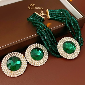 Macro view of emerald green jewelry set with necklace and stud earrings on leather