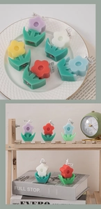 Detailed view of colorful flower scented candles on a wooden shelf with home decor