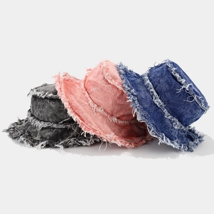 Close-up of retro frayed edge denim bucket hats in dark grey, coral pink and blue denim