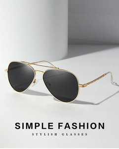 Detail of pilot-style sunglasses with golden metal frame and dark polarized lenses