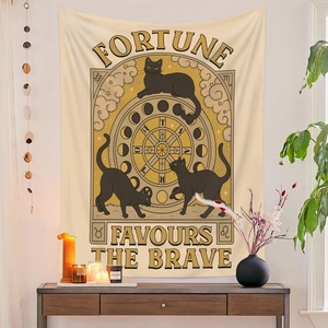 Detail of tarot tapestry featuring black cats and stars hung over a wooden console table