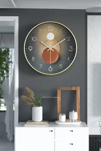 Détail d'une horloge murale moderne avec cadre en métal doré et cadran gris minimaliste
