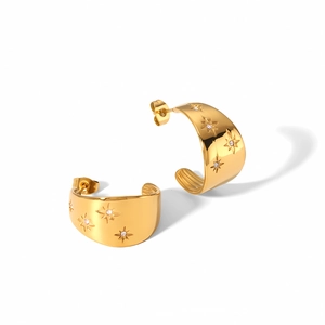 Detail of gold-plated half-hoop earrings with star engravings and embedded crystals